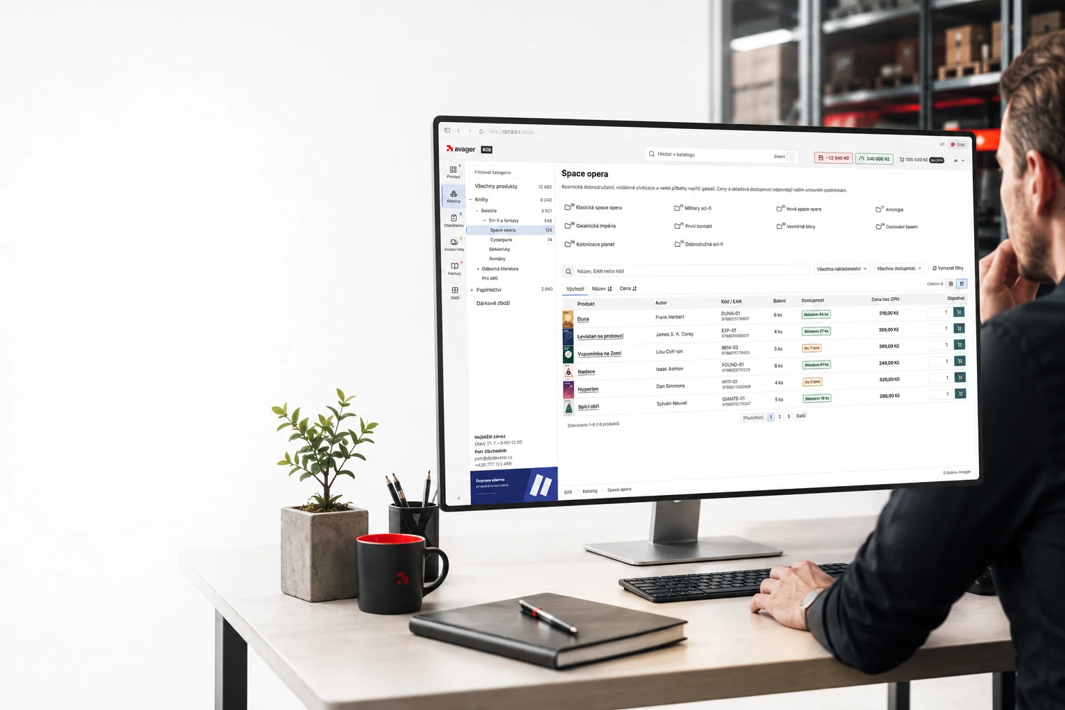 Pracovník sleduje katalog B2B aplikace na monitoru v moderním logistickém prostředí